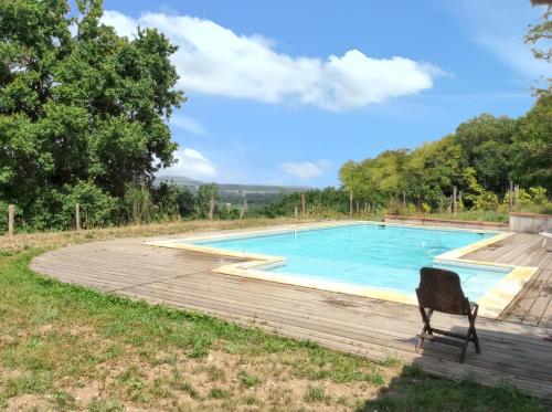 une chaise assise en face d'une piscine dans l'établissement Grande Villa à Villeneuve-sur-Lot avec Piscine Privée, à Villeneuve-sur-Lot