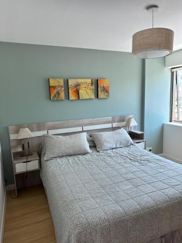 a bedroom with a bed with three paintings on the wall at Boulogne Design Suites in Mendoza