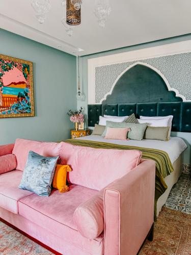 a living room with a pink couch and a bed at Nour Boutique Hotel in Dahab