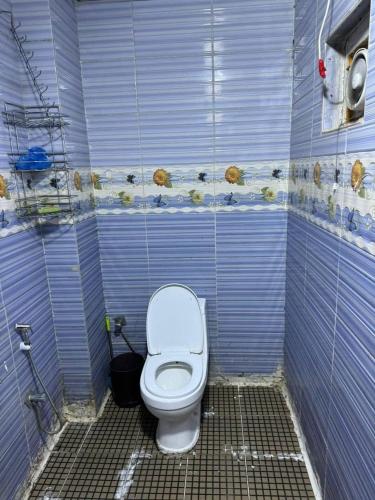 un bagno con un water in una cabina blu di Rawabi INN a Maţār al Malik Ḩusayn