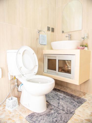 a bathroom with a white toilet and a sink at Ndovu Villas Limited in Watamu
