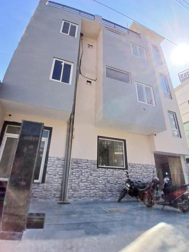 a motorcycle parked in front of a building at Hotel Braj Nikunj ! near new Rangj ji Temple, Prem mandir, ISCKON temple ! Fully air conditioned and prime located place in Vrindāvan