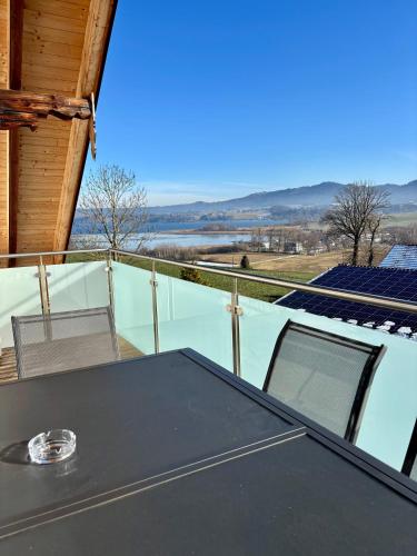 a table and chairs on the balcony of a house at Gästehaus Seeblick Penthousewohnung in Seekirchen am Wallersee