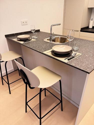 a kitchen with a counter with two chairs and a sink at VUT La Casa de la Sierra in El Barraco