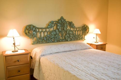 1 dormitorio con 1 cama y 2 mesitas de noche con lámparas en Rural Montes Málaga: Lagar Don Sancho, en Málaga