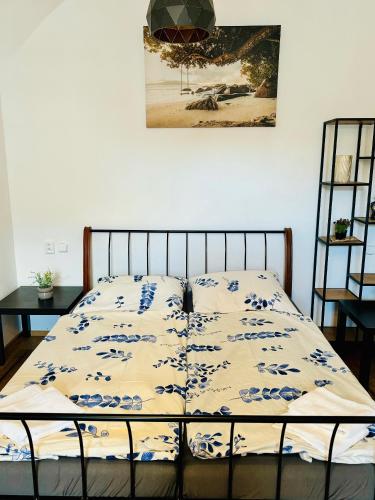 a bed with a comforter on it in a bedroom at Apartmán CORA in Jaroměř