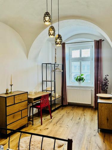 a room with a table and a window and a desk at Apartmán CORA in Jaroměř