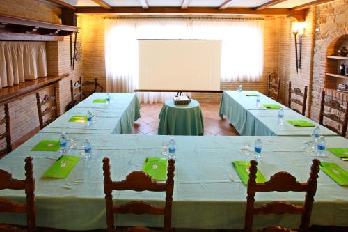 a meeting room with a long table with chairs and a screen at Hotel El Juglar in Olite