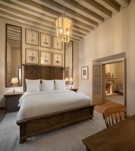a bedroom with a large bed and a chandelier at Casa Alondra in Morelia