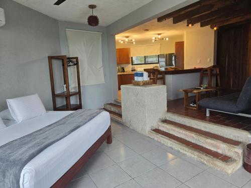a bedroom with a bed and a living room at Blue Caribe Bacalar Front Lagoon in Bacalar