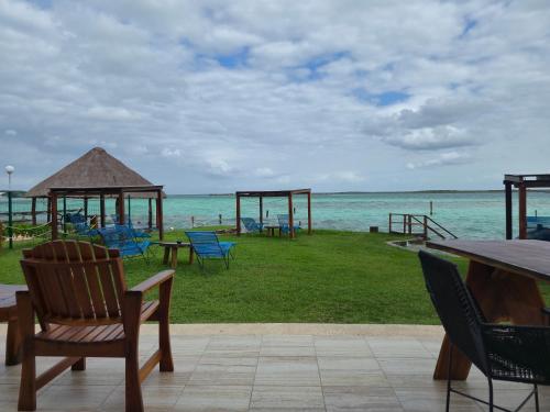 a picnic area with chairs and tables and the ocean at Blue Caribe Bacalar Front Lagoon in Bacalar