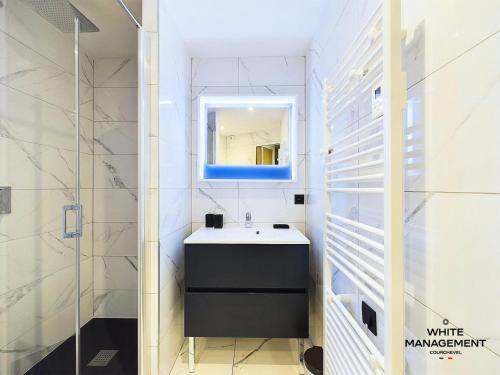 une salle de bain avec un lavabo et un miroir dans l'établissement Résidence Ariondaz Hellebore - Superbe appartement exposé Sud au pied des pistes MAE-2554, à Courchevel