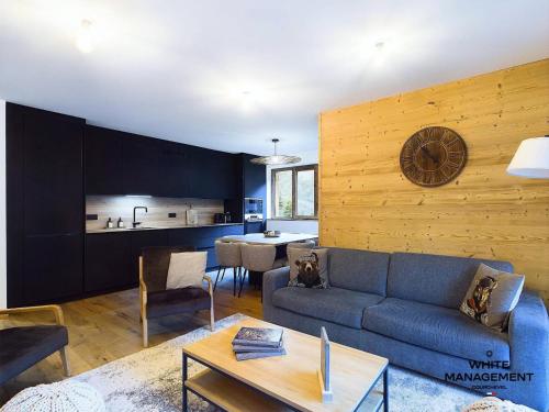 un salon avec un canapé bleu et une table dans l'établissement Résidence Ariondaz Hellebore - Superbe appartement exposé Sud au pied des pistes MAE-2554, à Courchevel