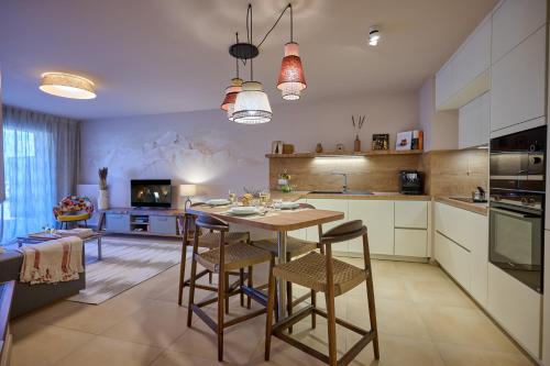 a kitchen with a table and chairs in a room at Le Miroir De Saint-Jacques in Sallanches