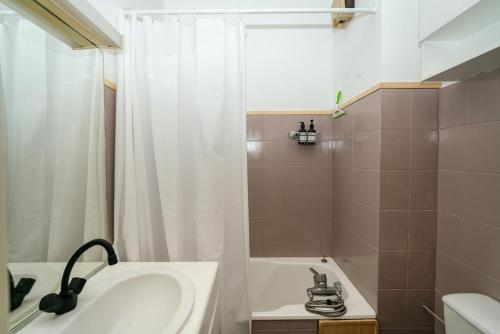 une salle de bain avec un lavabo, une baignoire et une douche dans l'établissement Le Cocon Du Lac, à Annecy