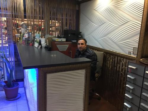 イスタンブールにあるÖrün Hotelの店のカウンターに座る男