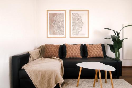 KüssabergにあるHoliday Apartment NAMASTAYの黒いソファとテーブルのあるリビングルーム