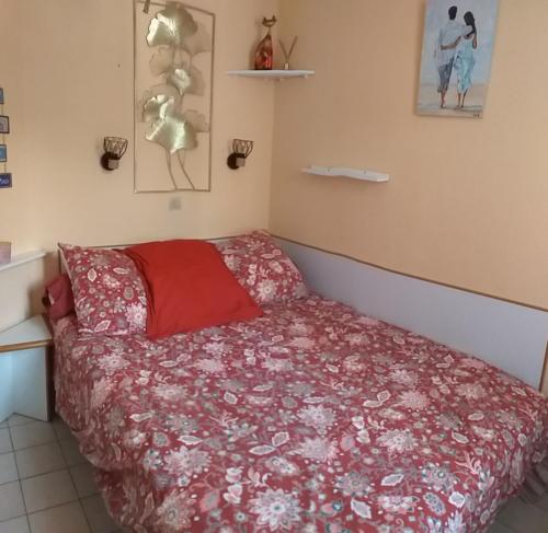 - une chambre avec un lit doté d'un couvre-lit rouge dans l'établissement La Goélette, à Talmont-Saint-Hilaire