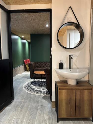 une salle de bain avec un lavabo et un miroir dans l'établissement Maison bien-être avec bain nordique et sauna, à Ferrières