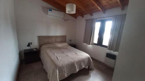 ein Schlafzimmer mit einem Bett und einem Fenster in der Unterkunft Casa Amsterdam in Villa Carlos Paz