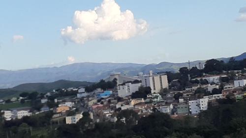 a group of buildings on a hill with a cloud at Casa de Hospedagem Mirante Padre Leo in Cachoeira Paulista