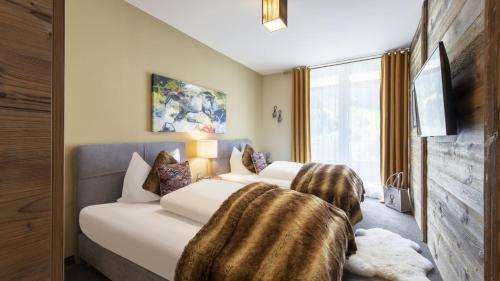a hotel room with two beds and a window at Alpine Myth in Sankt Anton am Arlberg