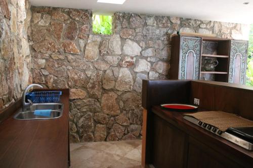 a stone kitchen with a sink and a stone wall at Casa Mar Beachfront Jungle Villa in Palapa Ganesh in Sayulita