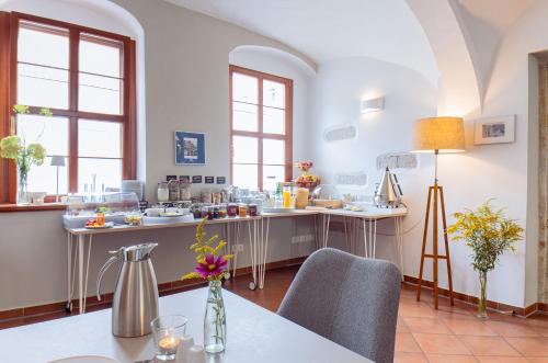a kitchen with a table and chairs and windows at Boutique Hotel am Schillerplatz in Dresden