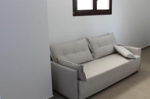 a couch sitting in a room with a window at Villa Maria - Mola Suites in Kassandria