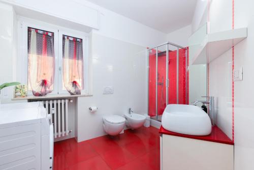 a bathroom with two toilets and a red floor at TERRAZZA SUL LAGO - Open Space e Netflix in Lecco