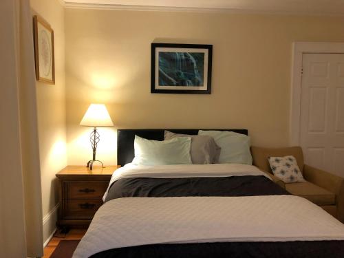 a bedroom with a bed and a lamp on a table at Brick House Retreat in Hamlet