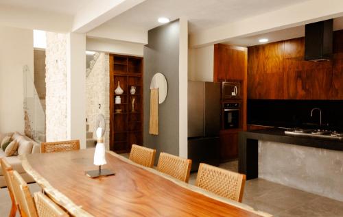 a kitchen with a wooden table and some chairs at Casa Cactus Luxury Villa in Bacalar