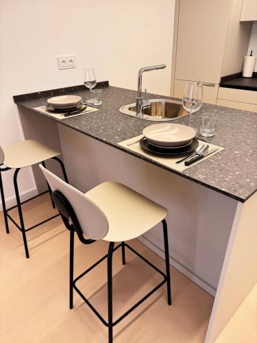 a kitchen with a counter with two chairs and a sink at VUT La Casa de la Sierra in El Barraco