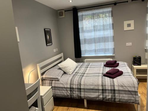 a bedroom with a bed with two towels on it at Cosy Rooms next to St Pancras Station in London