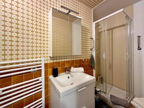 une salle de bain avec un lavabo, une douche et un miroir dans l'établissement Près de Deauville, vue mer, parking, à Trouville-sur-Mer