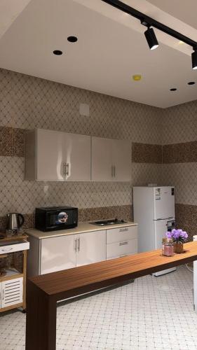 a kitchen with white cabinets and a white refrigerator at Twilight apartment in Buraydah