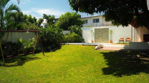 a yard with a building and a grassy yard at Sayaná House in Temixco