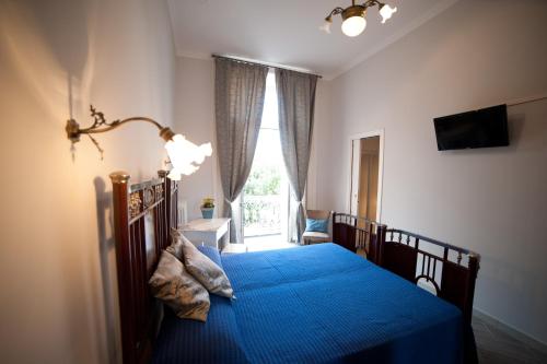 Un dormitorio con una cama azul y una ventana en B&B Terrazza Flora en Campobasso