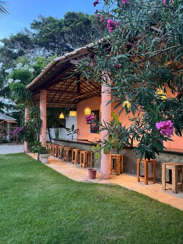 a building with tables and a green lawn at Pousada Vila Flow in Cumbuco