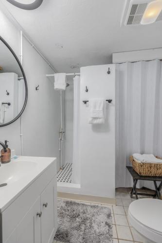 a white bathroom with a shower and a toilet at Moose Suite 1King Bed 1Queen Sofa bed + Hot Tub in Gatlinburg