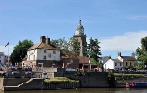アップトン・アポン・セバーンにあるCentral Upton Upon Severn 2 bedroom property sleeps 6の時計塔のある水辺の町