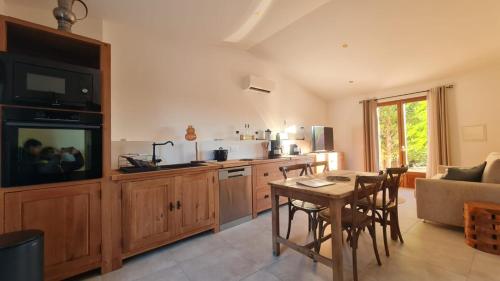 - un salon avec une cuisine et une table avec des chaises dans l'établissement La Cigale suite villa du Mazet de la Draille Mas en Cévennes - Jacuzzi & Piscine Privatif - 4 personnes - Classé 5 étoiles, à Bagard