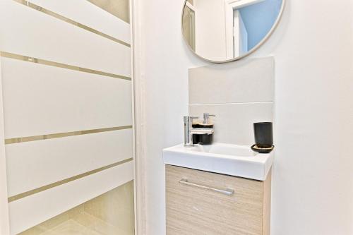 une salle de bain avec un lavabo et un miroir dans l'établissement Charming little studio close to Paris- III, à Asnières-sur-Seine