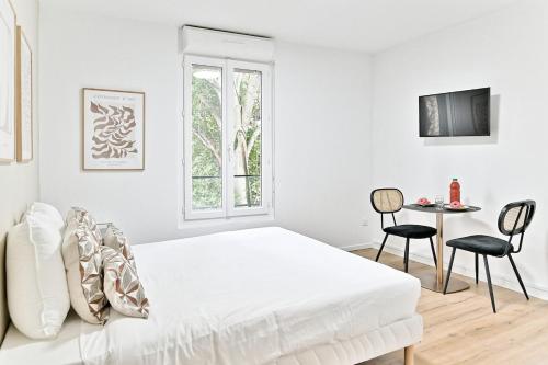 une chambre blanche avec un lit, une table et des chaises dans l'établissement Charming little studio close to Paris- III, à Asnières-sur-Seine