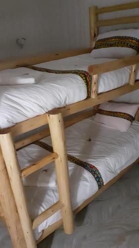 a pair of bunk beds with white sheets and ropes at 2 Envubu Cottage - Benanda Forest Resort in Masaka