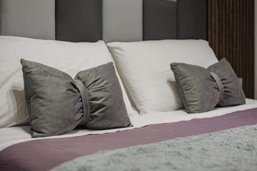 a bed with white pillows and gray pillows at Il Dubbio ai Quartieri Spagnoli in Naples