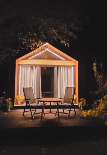 a picnic table and two chairs in front of a tent at Tiny House in Sankt Johann im Pongau