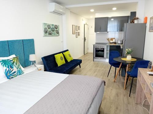 a bedroom with a bed and a living room with a kitchen at Garden House Fundão in Fundão
