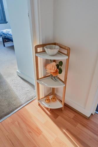 a shelf with a bowl and a vase on it at Modern Cosy Two Bed in Tilbury