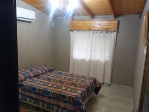 a small bedroom with a bed and a curtain at EZEIZA 10 minutes the air port, barrio privado la celia quinta tauro in Ezeiza